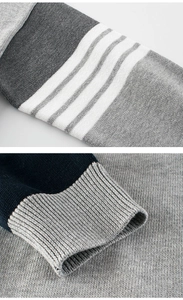 Detail showing grey knit fabric with white stripes and dark blue ribbed cuff design