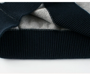 Close-up of contrast knit fabric with navy ribbed cuffs and gray textured stitching