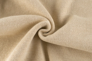 Close-up of beige knit fabric showing soft texture and fine stitching detail