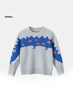 Detailed close-up of blue cartoon crocodile jacquard and ribbed cuffs on grey knit sweater