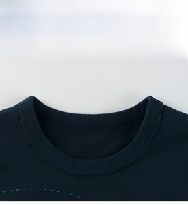 Close-up of a navy blue crew neck collar with ribbed edging and neat stitching on kid's shirt