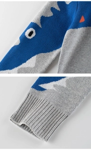 Detail of dinosaur jacquard knit and elastic ribbed cuffs on a blue toddler sweater