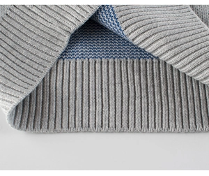 Close-up of grey ribbed knit cuffs and blue jacquard lining on the children sweater