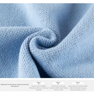 Detail of light blue knit fabric texture and safety standards classification label