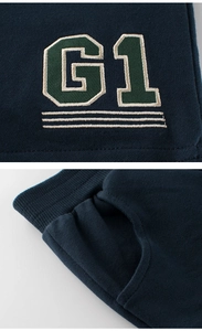 Close-up of navy knit shorts featuring G1 letter embroidery and ribbed elastic waistband