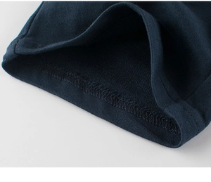 Detailed close-up of high-quality knit stitching and seams on navy blue kids' cotton shorts