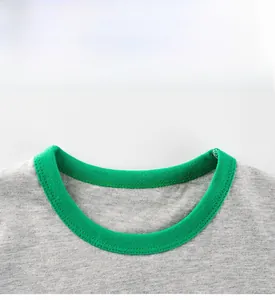 Détail d'un t-shirt gris en coton avec un col rond contrasté vert et des coutures doubles