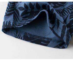 Détail de l'imprimé feuilles tropicales sur short en coton bleu marine et couture
