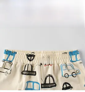 Detail view of children's cotton shorts with cartoon car print and elastic waistband