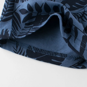Gros plan du short pour garçon bleu foncé avec imprimé tropical et couture précise