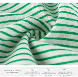 Gros plan sur le tissu en coton rayé vert et blanc pour shorts pour enfants