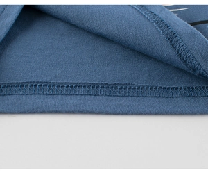 Macro detail of high-quality double-needle hem stitching on blue cotton kids' vest