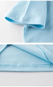 Detail of high-quality stitching on the cuff and hem of a light blue cotton kids' T-shirt
