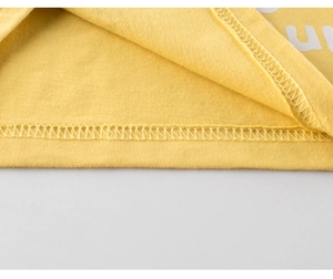 Detail of double-needle stitching on bright yellow cotton knit fabric for children