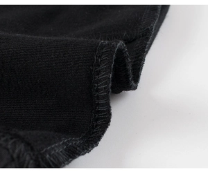 Vue détaillée des coutures doubles sur l'ourlet du short noir en maille pour garçons