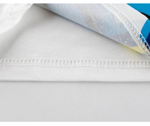 Macro shot of double-needle stitching and colorful dinosaur print on cotton toddler T-shirt