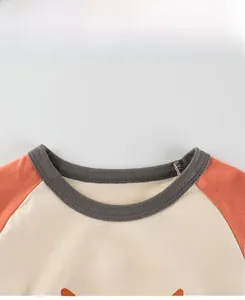Detail display of kids raglan sleeve cotton t-shirt with ribbed neck and orange art print