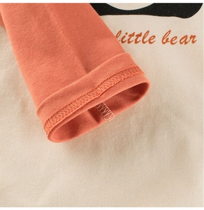 Detail of cotton knit toddler shirt with little bear print and ribbed caramel cuffs