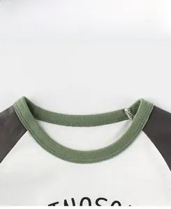 Detail of boys' raglan T-shirt with green ribbed neckline and cotton fabric texture
