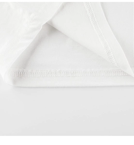 Détail de la couture à double aiguille et du tissu en coton sur un t-shirt blanc enfant