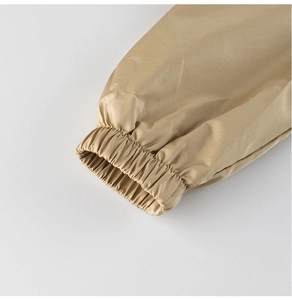 Detail of khaki windproof jacket elastic cuff showing fabric texture and stitching