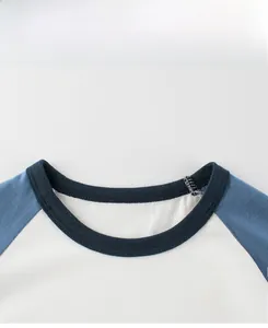 Close-up of crew neck and raglan sleeve stitching on white and blue boys cotton T-shirt