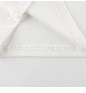 Close-up of high-quality cotton fabric stitching and neat hem detail on white kids T-shirt
