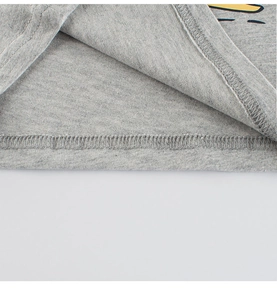 Détail de la couture et de la texture en maille de coton gris du t-shirt dinosaure garçon