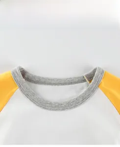 Detail view of cotton crew neck collar and raglan sleeve stitching on kids t-shirt