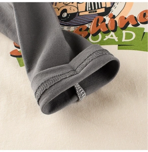 Detail of cotton kids long sleeve shirt showing cuff stitching and vintage car print