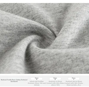 Detail der weichen grauen Baumwollstrickstruktur mit Etiketten zur Sicherheitszertifizierung