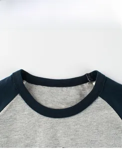 Detailansicht der Baumwoll-Rundhalsausschnittnaht am grau-blauen Raglan-T-Shirt für Kinder