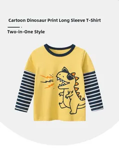 Détail d'un t-shirt jaune pour garçon avec imprimé dinosaure et manches rayées bleues