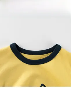 Détail du col d'un t-shirt jaune en coton avec surpiqûres côtelées bleu marine