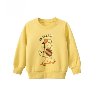 Detail of soft yellow cotton kids sweatshirt with cartoon dinosaur skateboarding print