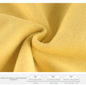 Close-up of ginger yellow cotton knit fabric showing soft texture and GB safety standards
