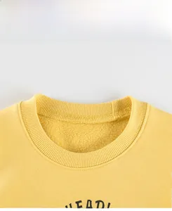 Detail display of yellow kids sweatshirt featuring a ribbed crewneck and warm fleece lining