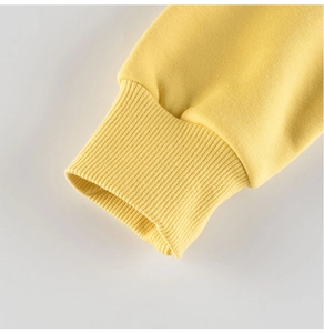 Close-up of bright yellow ribbed cuffs on a kid's sweatshirt showing cotton knit texture