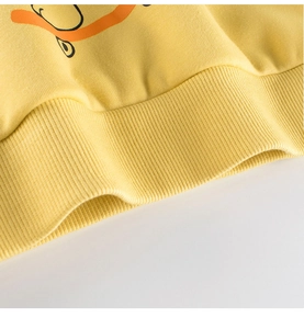 Detail of yellow toddler sweatshirt showing ribbed hem and soft cotton fabric texture