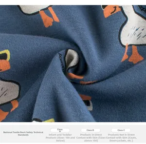 Detail of blue cotton fabric with cartoon duck print and soft texture for children