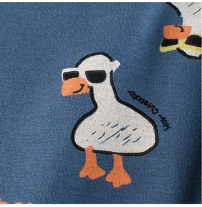 Detail of navy knit fabric with cute cartoon duck wearing sunglasses and Hey Cutebaby text