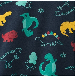 Close-up of navy knit fabric featuring colorful cartoon dinosaur prints for children clothes