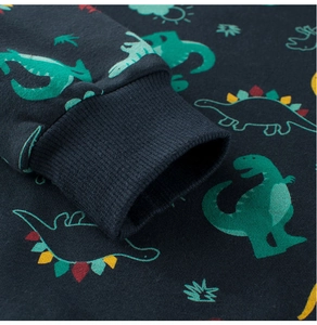 Detail of ribbed cuffs on navy blue kids sweatshirt with colorful dinosaur prints