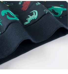 Detail of ribbed hem on navy blue kids sweatshirt with cartoon dinosaur and star patterns