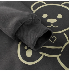 Close-up of charcoal gray toddler sweatshirt featuring ribbed cuffs and yellow bear print