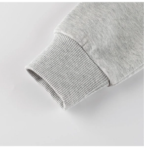 Detailed close-up of ribbed cuffs on a light grey heathered cotton blend kids sweatshirt