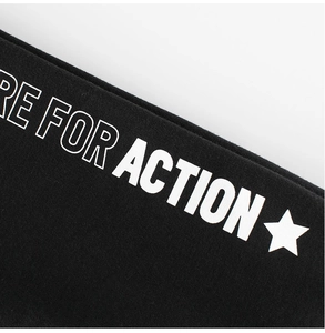 Close-up of black fleece joggers for kids featuring white RE FOR ACTION graphic print