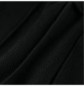 Close-up of thick black polar fleece fabric texture showing soft warmth and material detail