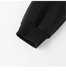 Close-up of elastic ribbed cuffs on children's heavy fleece trousers in solid black