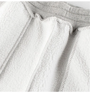 Detail of gray ribbed waistband and thick white fleece lining for kids warm sports pants